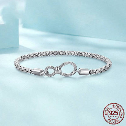 Sterling silver infinity knot bracelet on blue background