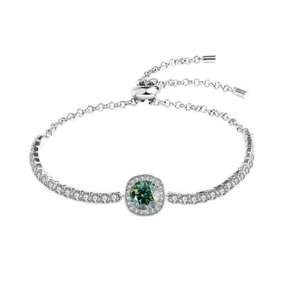 Silver moissanite galaxy bracelet with a green central stone, surrounded by shimmering stones in a galaxy design.