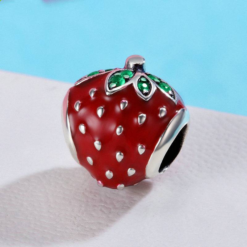 Close-up of a Strawberry Charm featuring red enamel and silver details, perfect for bracelets and necklaces to enhance any outfit with a fruity flair.