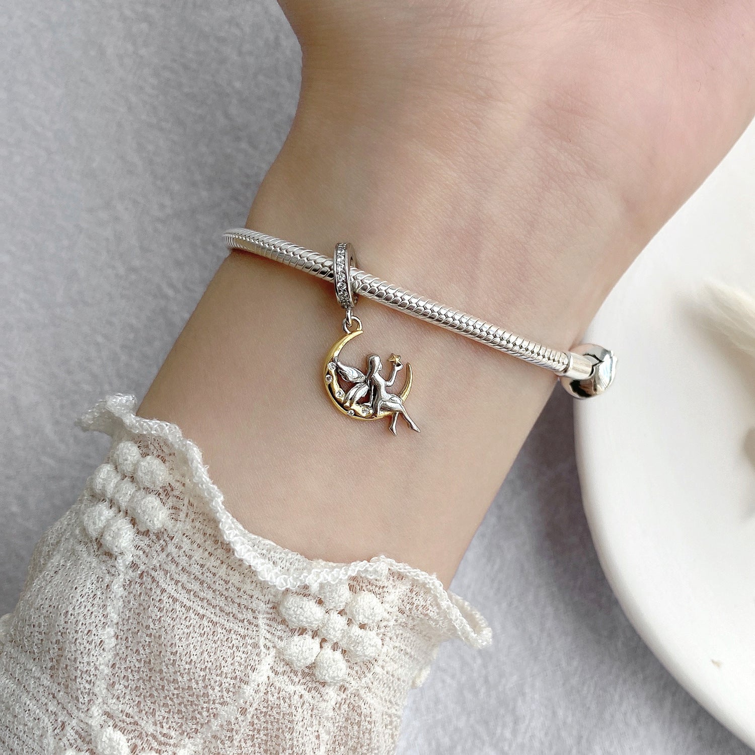 Close-up of Moon Fairy Charm on a silver bracelet, highlighting its detailed craftsmanship with a fairy on a crescent moon, ideal for enchanting jewelry collections.