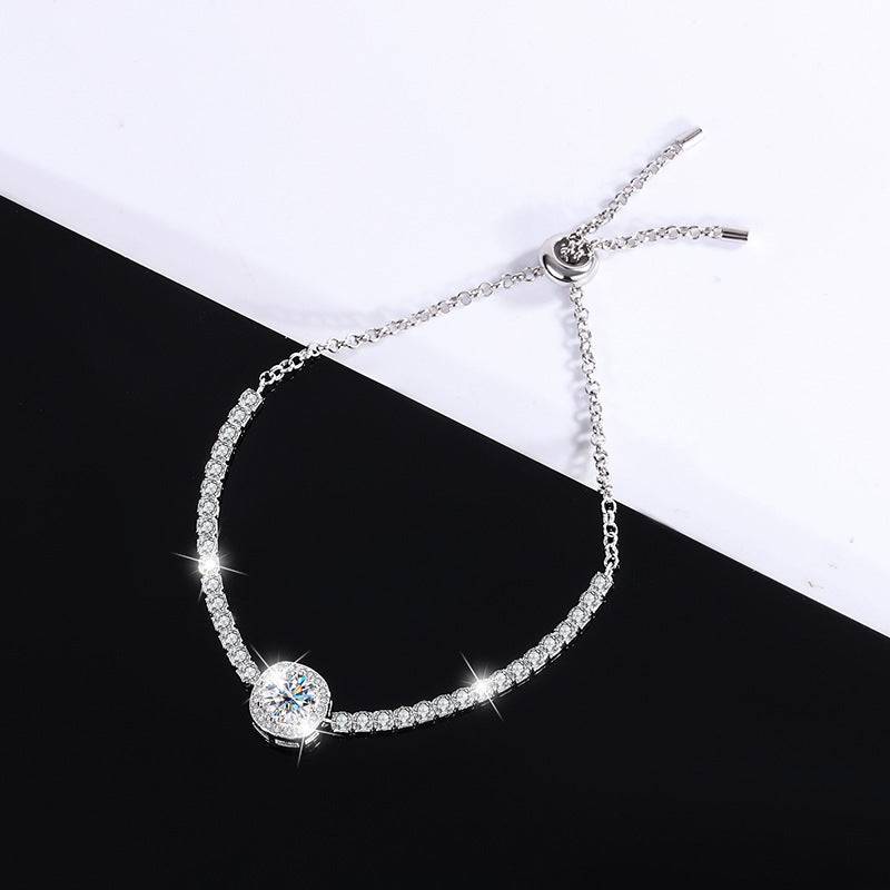 Silver moissanite galaxy bracelet with a clear central stone, displayed on a contrasting black and white background.