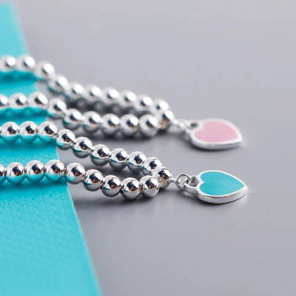 Silver bracelets with pink and blue heart tags